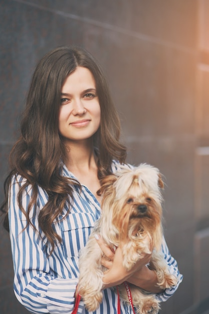 Fille marche avec un chien dans la rue de la ville.