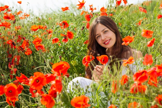 Fille marche dans un champ de coquelicots