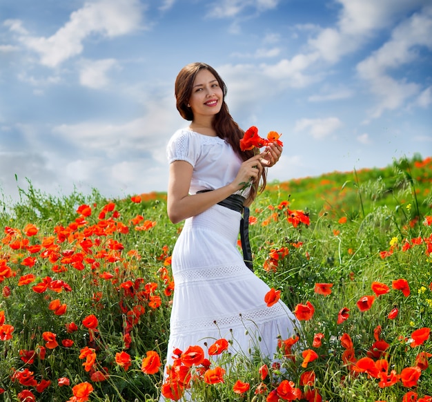 Fille marche dans un champ de coquelicots