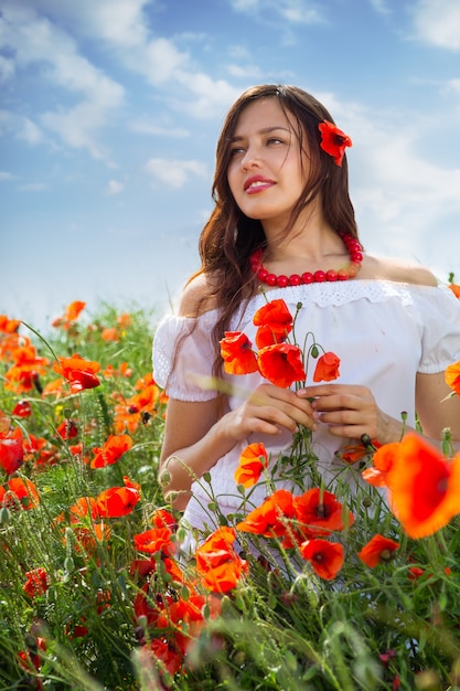 Fille marche dans un champ de coquelicots