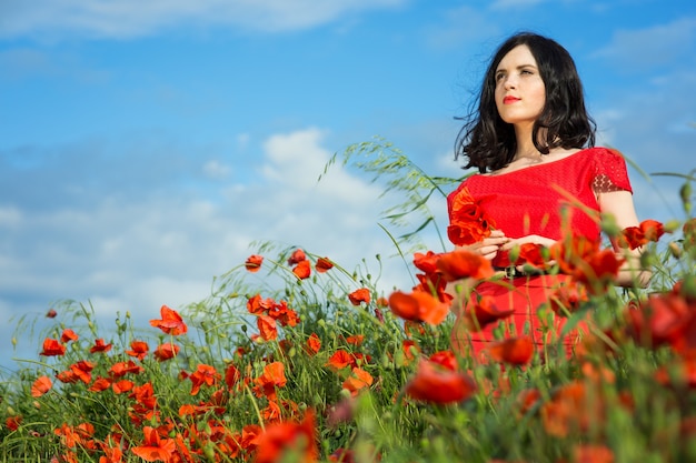 Fille marche dans un champ de coquelicots