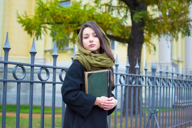 La fille marche dans la rue avec un livre