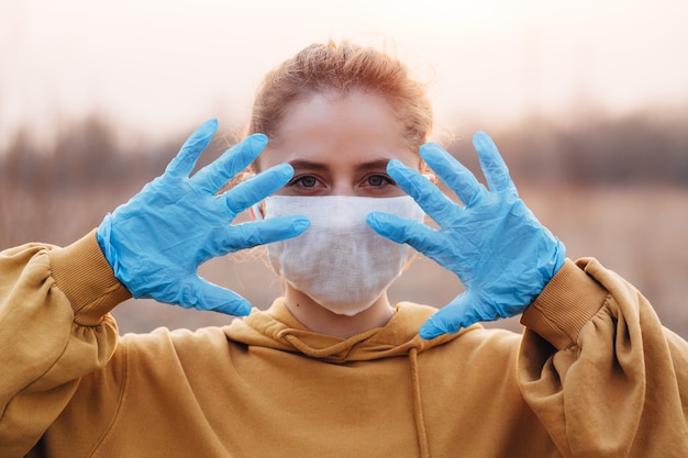 Fille en masque et gants bleus pendant la quarantaine