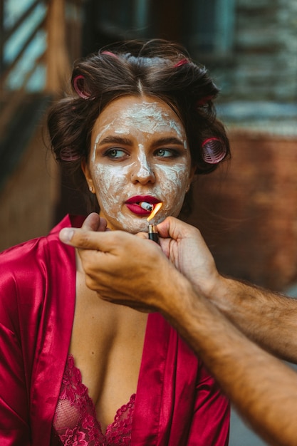 Fille avec masque et peignoir de bain fumer