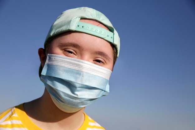 Fille avec un masque sur son visage sur fond de ciel bleu