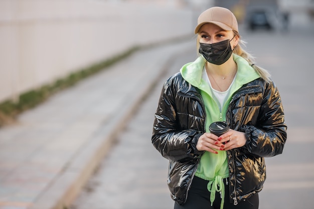 Une fille masquée marche le long de la rue infection à coronavirus covid