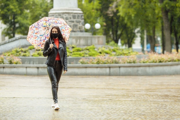 Une fille masquée marche le long de la rue