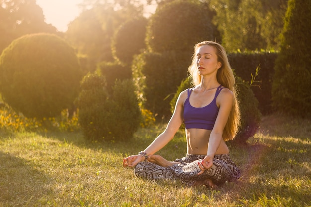 Une fille médite dans la nature.