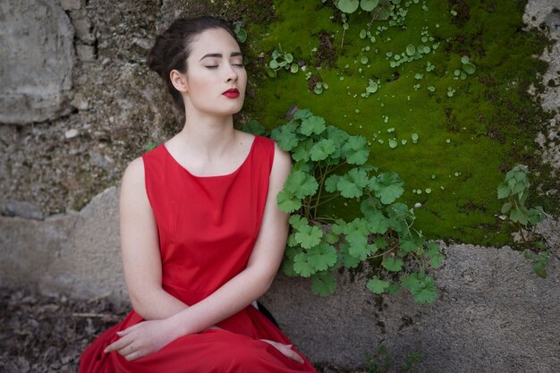 Fille mélancolique avec une robe rouge dans la nature