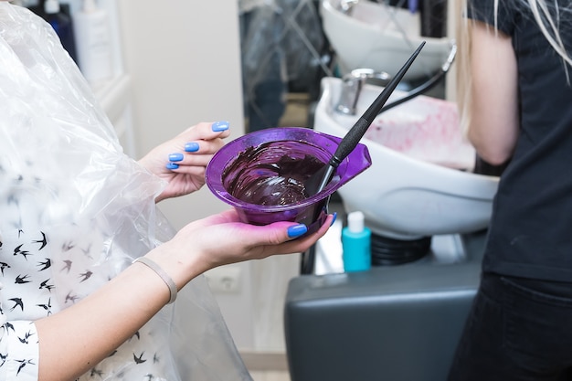 La fille mélange la teinture pour les cheveux violette