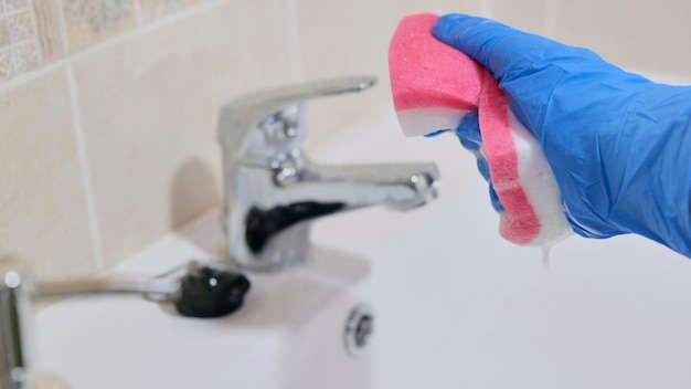 Fille de ménage nettoyant les toilettes avec un tampon à récurer avec du savon portant des gants