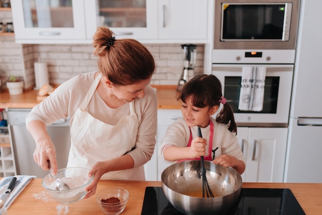 Fille et mère cuisinant à la maison un délicieux dessert pour la fête des mères