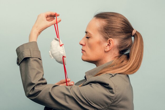 Une fille met un masque de protection. Protection respiratoire contre les coronavirus. Équipement de protection individuelle en cas de pandémie d'infection virale. Covid19.