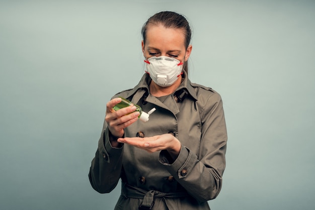 Une fille met un masque de protection. Utilisation d'un gel antiseptique. Protection respiratoire contre les coronavirus. Équipement de protection individuelle en cas de pandémie d'infection virale. Covid19.