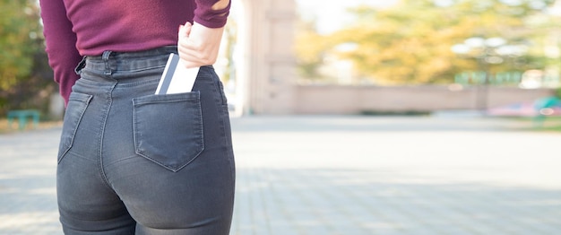 Fille mettant la carte de crédit dans la poche de jeans