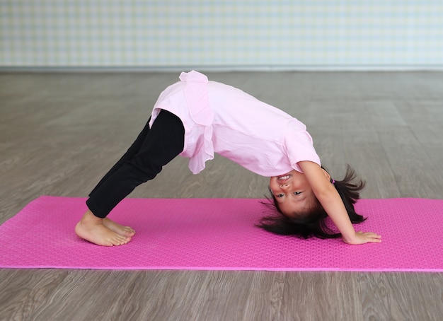 Fille mignon bambin pratiquant le yoga et faire de l&#39;exercice