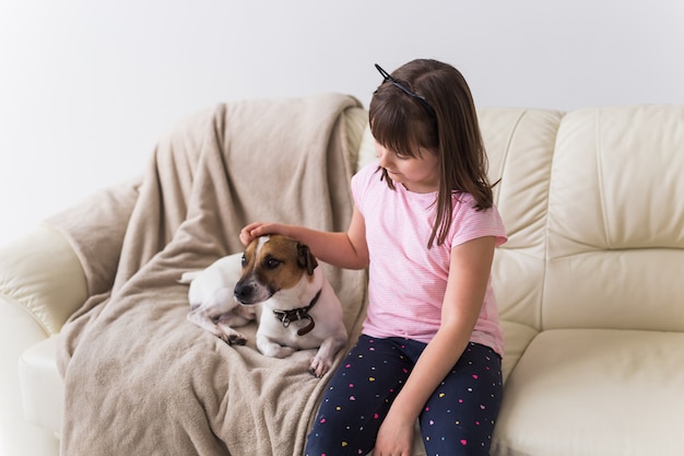 Fille avec mignon chien jack russell terrier sur le canapé