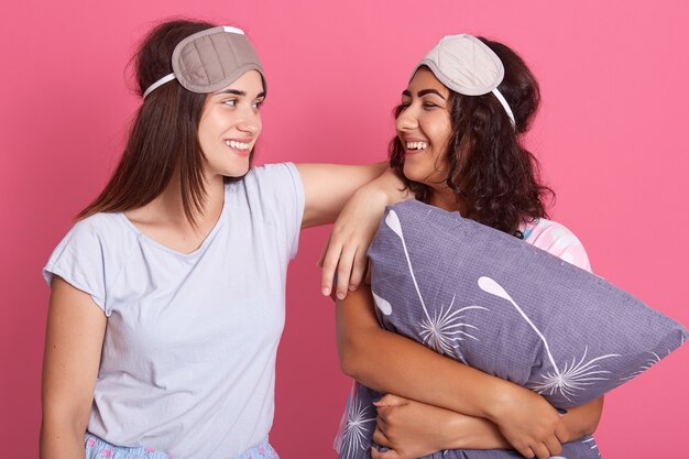 Photo fille mignonne d'amis en costume de nuit pour une soirée pyjama sur fond rose