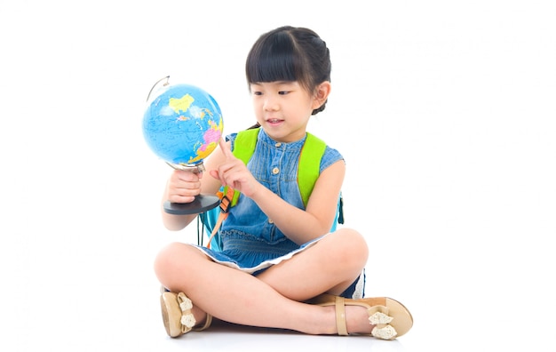 Fille mignonne asiatique regardant le globe