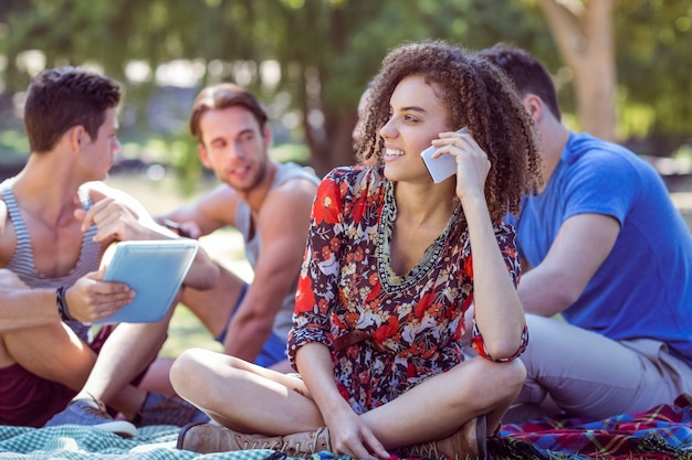 Fille mignonne cheveux bouclés sur le téléphone dans le parc