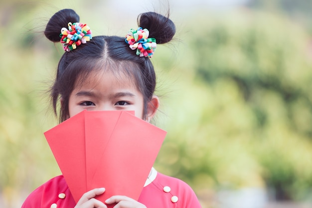 Fille mignonne enfant asiatique tenant une enveloppe rouge