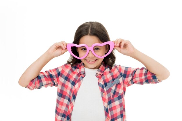 Fille mignonne enfant souriant visage coeur lunettes Concept de symbole d'amour Tomber amoureux Concept d'amour d'enfance Enfant charmant sourire tomber amoureux Fille lunettes en forme de coeur célèbre la Saint Valentin