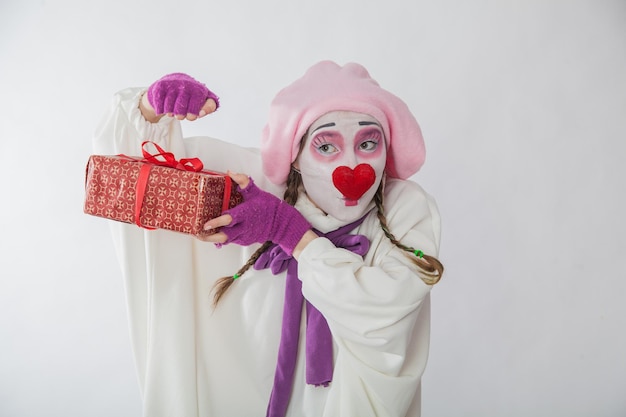 Fille mime avec un cadeau dans ses mains Émotions d'un cadeau