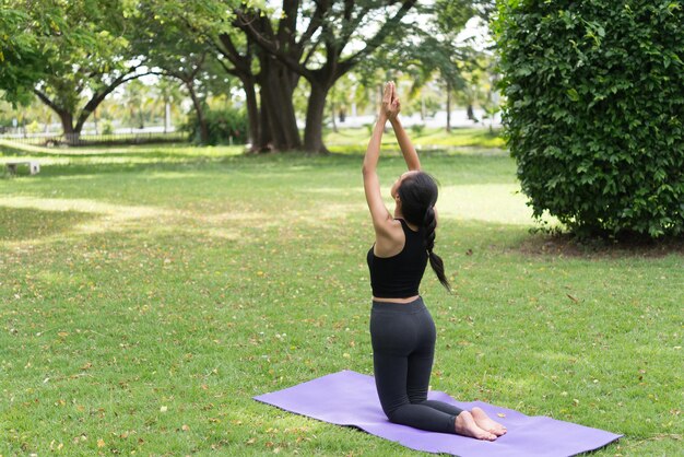 Fille mince jouer au yoga sur la pelouse au parkrelax in nutureLes filles asiatiques aiment la santé en pratiquant le yoga