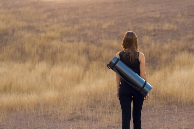 Une fille mince sportive en leggings et un haut se reposant entre les exercices.