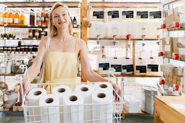 Une fille minimaliste heureuse achète du papier toilette sans emballage en plastique dans un magasin zéro déchet