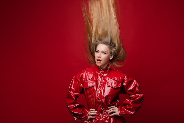 Fille à la mode en combinaison rouge avec les cheveux à l'envers.