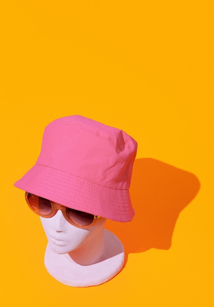 Fille de mode factice dans des lunettes de soleil d'été élégantes et un chapeau de seau Concept de vacances de magasin de fête Fond d'écran isométrique minimaliste