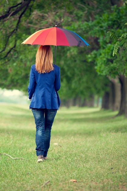 Fille de mode jeune avec parapluie au printemps en plein air.