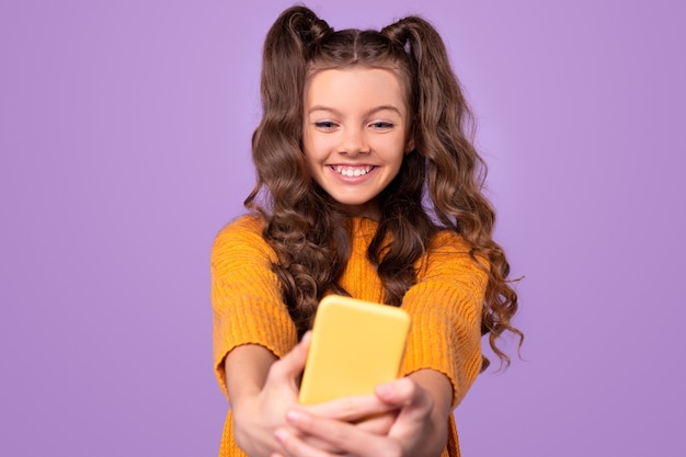 Fille à la mode souriant et prenant selfie