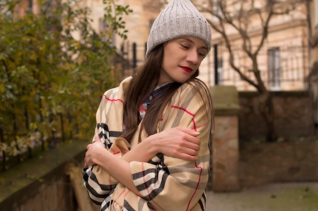 Fille à la mode vêtue d'un manteau gris à la ville