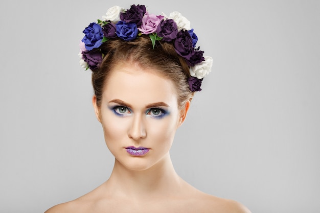 Fille de modèle de mode beauté avec des fleurs dans les cheveux. Maquillage créatif parfait et coiffure art floral.