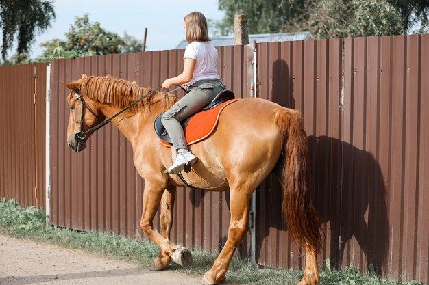 Une fille monte à cheval pendant l'été chaud