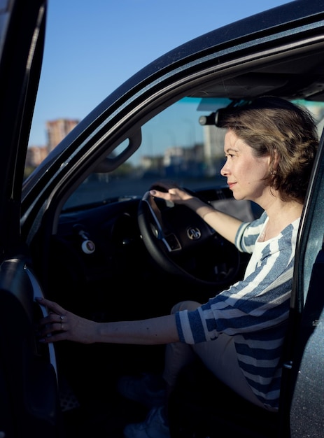 Une fille monte dans sa voiture