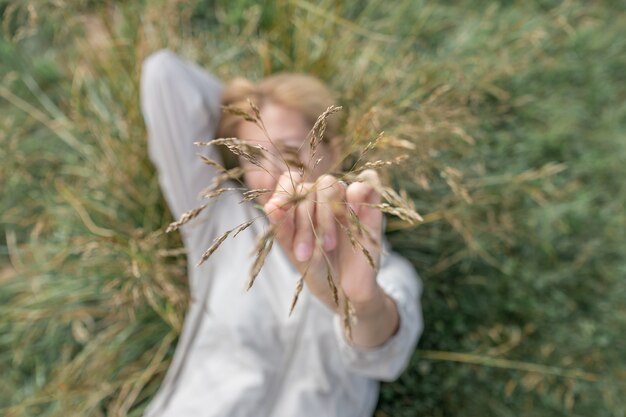 Photo fille montrant l'herbe d'or sèche à l'été