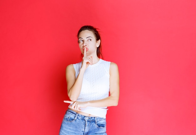 Fille montrant quelqu'un sur le côté gauche.