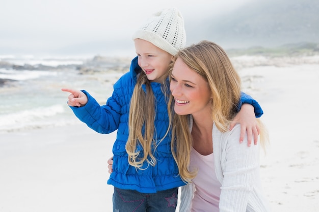 Fille montrant quelque chose à la mère à la plage