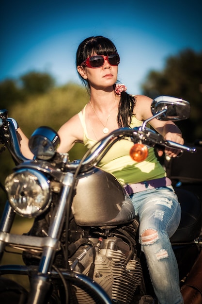 Photo la fille de motard s'assied sur une moto