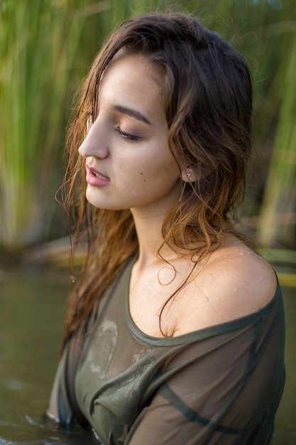 Fille mouillée dans l'eau avec des roseaux, portrait émotionnel d'une fille dans l'eau