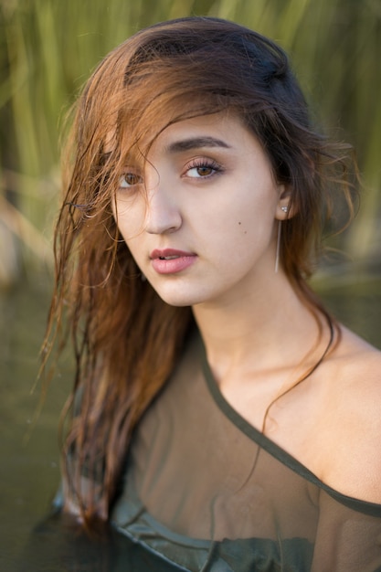 Fille mouillée dans l'eau avec des roseaux, portrait émotionnel d'une fille dans l'eau