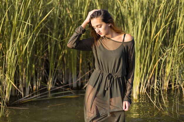 Fille mouillée dans l'eau avec des roseaux, portrait émotionnel d'une fille dans l'eau