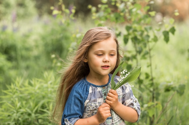 fille avec muguet dans la nature