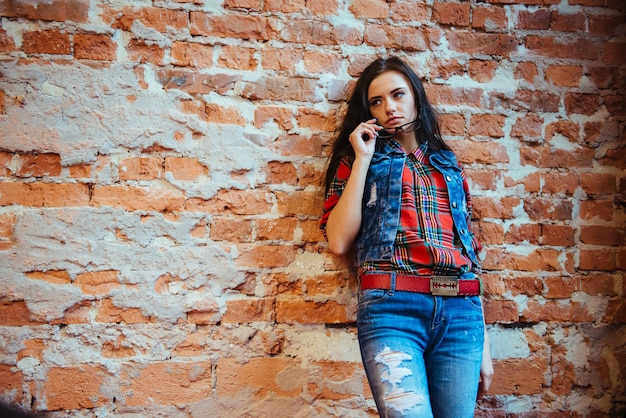 Fille sur un mur de briques. Couleurs chaudes.