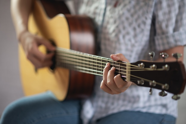 Fille musicienne jouant de la guitare acoustique