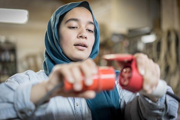 Fille musulmane branchant un câble électrique