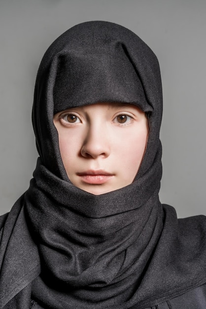 Photo fille musulmane en hijab noir sur fond gris